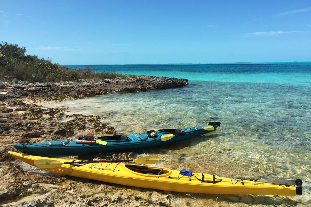 Kayaks on the beach with crystal blue waters