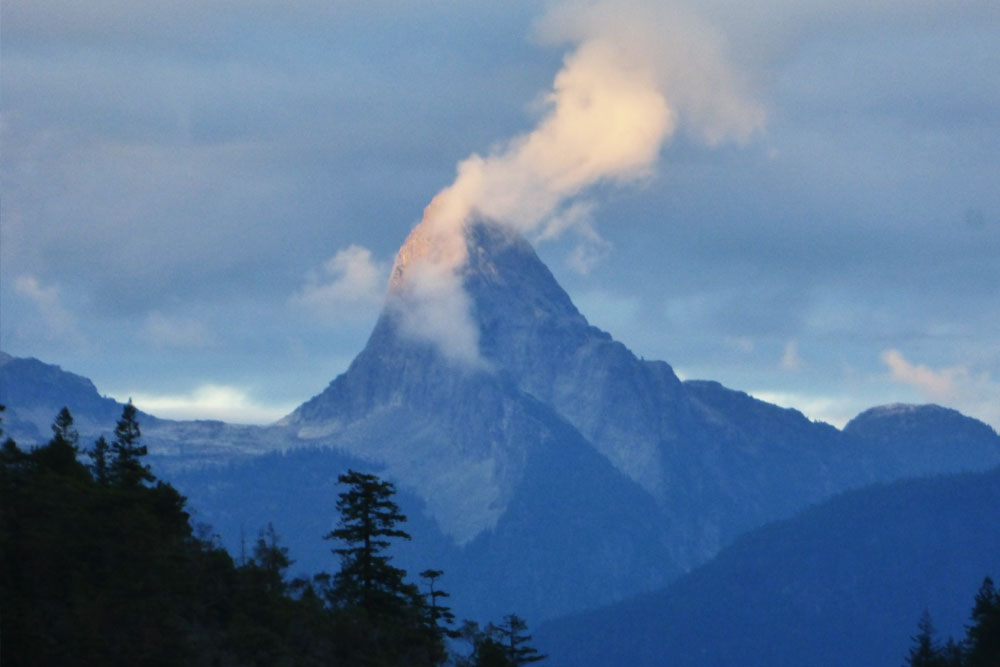 Towering mountain in the clouds coastal BC