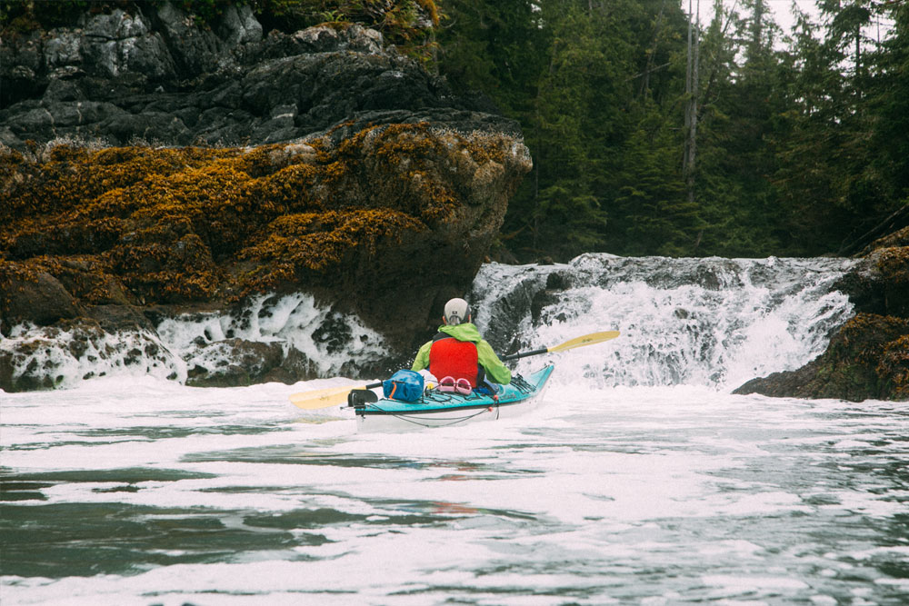 Kayaker paddling towards a waterfall