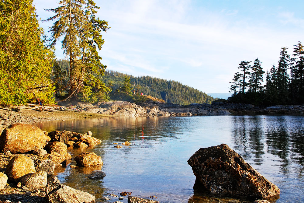 Guests standing on sheltered rocky cove