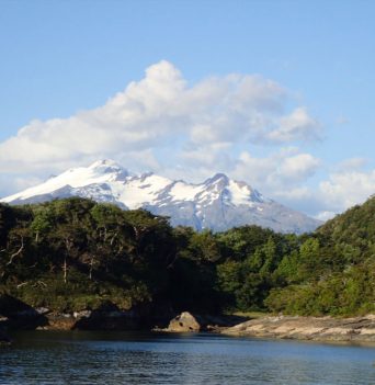 A snowcapped mountain towering over a bay in Chile
