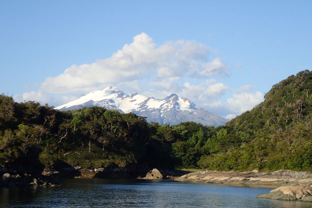 A snowcapped mountain towering over a bay in Chile