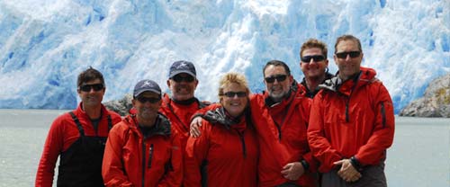 A group of people standing in front of the San Rafael Glacier in Chile