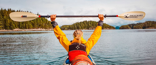 Kayaker holding paddle above head in the Johnstone Straight