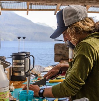 A guide preparing a meal in the outdoor kitchen at our basecamp