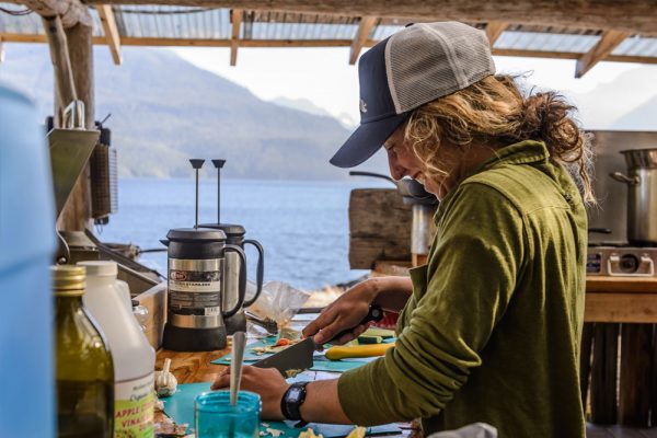 Staff in outdoor kitchen preparing meal