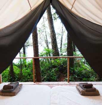 Canvas tent interior with fresh linens at glamp basecamp