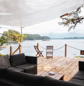 Sheltered outdoor area with couches and deck at glamping basecamp