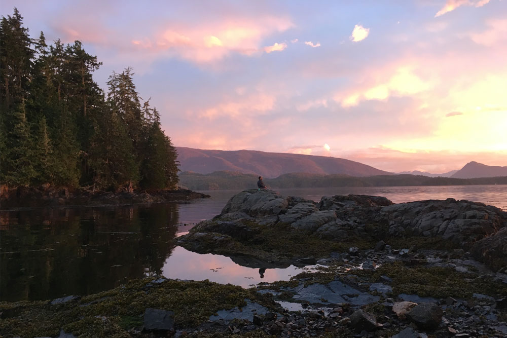 Man watching the sunset from the rocky bluffs of Blackfish Sound.