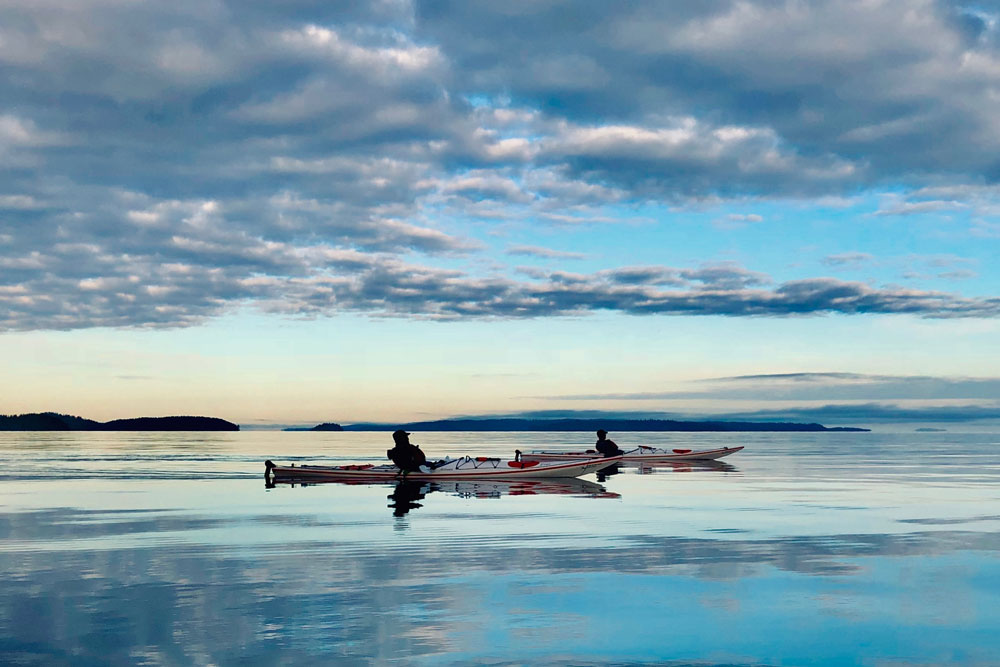 Kayakers enjoying sunset paddle on glassy water