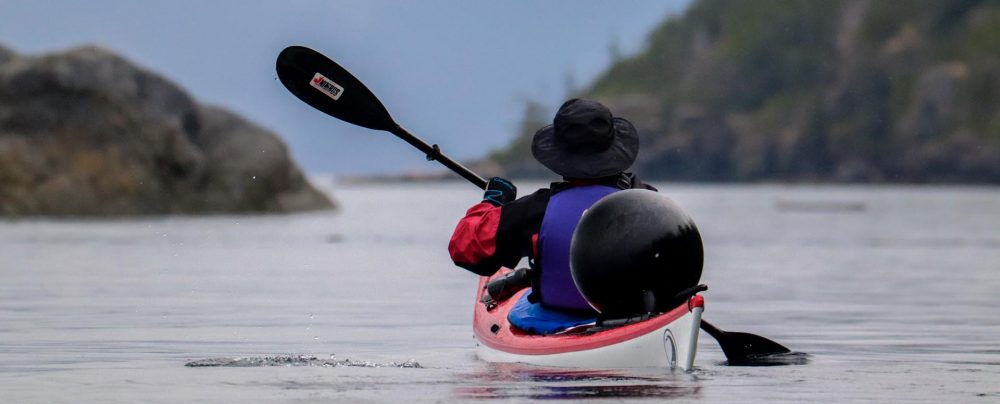 Kayaker carrying beach garbage