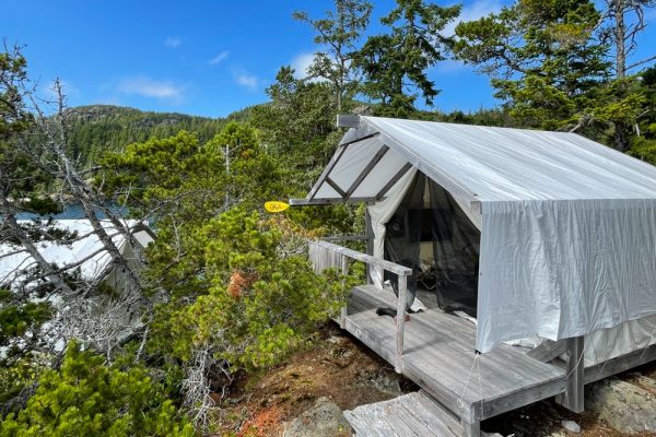 A glamping style safari tent on a platform overlooking the ocean