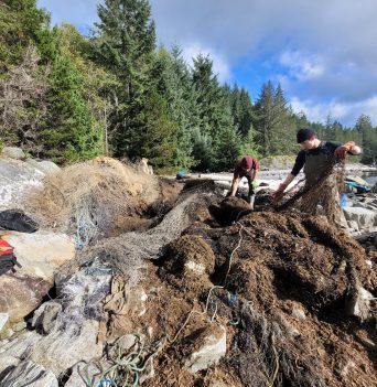 Crew removing old fishing net from beach