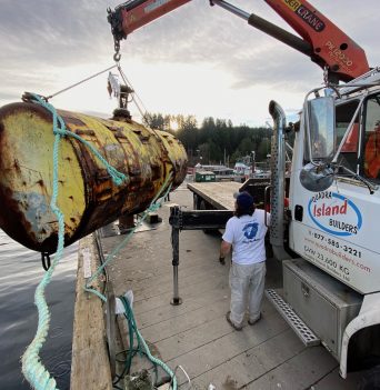 Large steel mooring float getting lifted onto truck