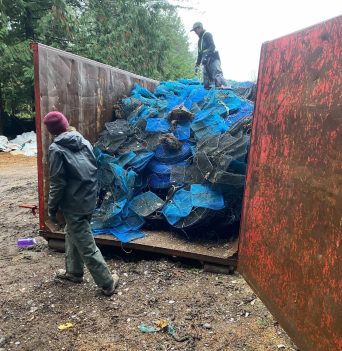 Filling metal recycling dumpster with aquaculture gear