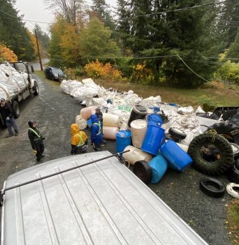 Truck and workers unloading bags of debris at Quadra operations base