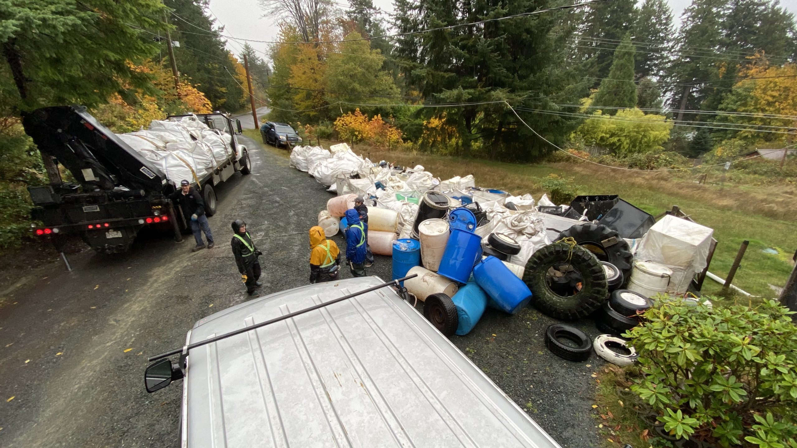 Truck and workers unloading bags of debris at Quadra operations base