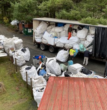 Loading sacks of marine debris onto transport truck for recycling