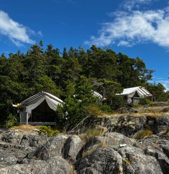 A collection of glamping tents on a rocky bluff overlooking the Johnstone Strait