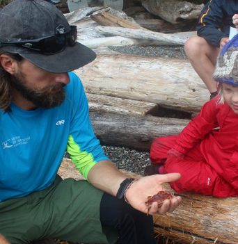 A guide teaching a guest about intertidal life