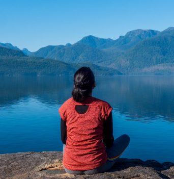 A guest sitting in the sunlight enjoying the view of the Johnstone Strait