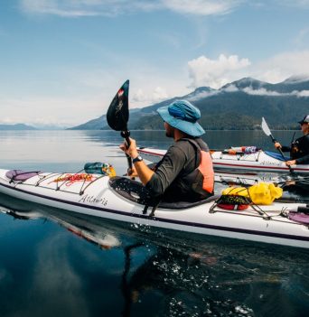 CClose-up of paddlers skimming across the water with scenic views