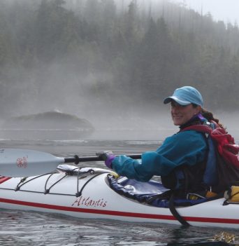 Happy kayaker paddling through fog