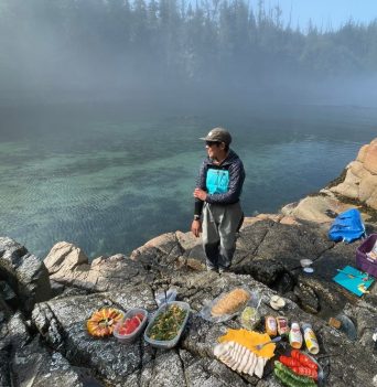 Tour guide preparing food on whale watching glamping tour