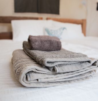 Fresh linens and towels on twin bed at basecamp