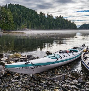 Two kayaks docked on rocky shore in coastal BC