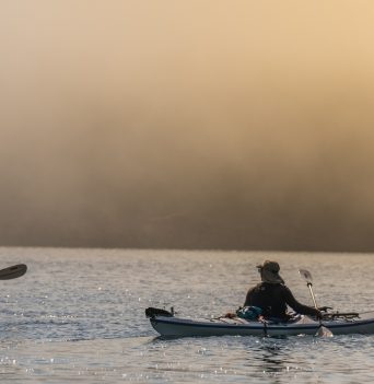 Sunrise paddle with golden haze over the water