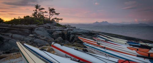 Sea kayaks on the beach at sunset