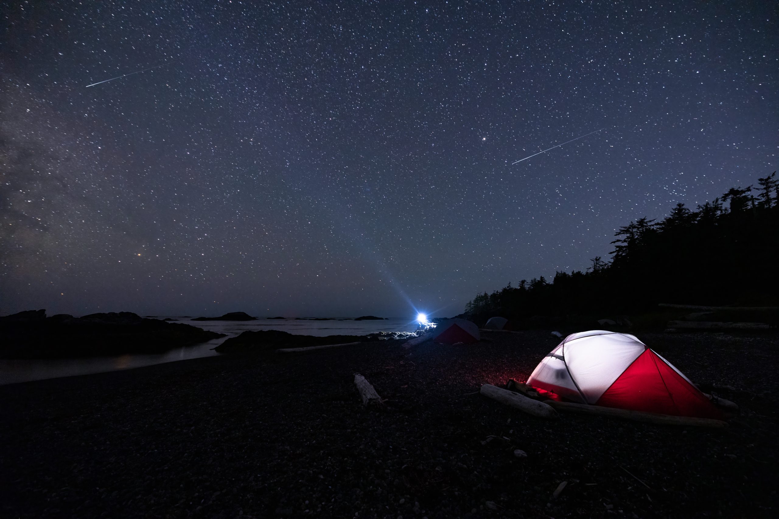 Red and White Tent Glows in Extended Exposure Beneath Clear Starry Sky in Coastal BC