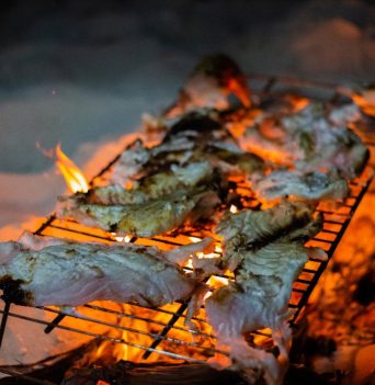 Food cooking on a grill over a fire on a Bahamaian beach