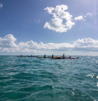 A kayaker paddling through small waves in the Bahamas