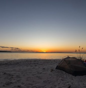 A tent on a beach at sunset in The Bahamas