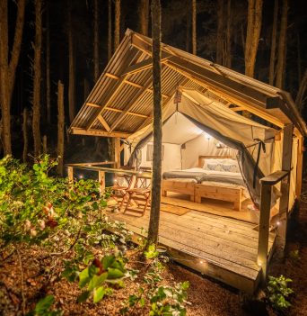 Large glamping tent lit up at night
