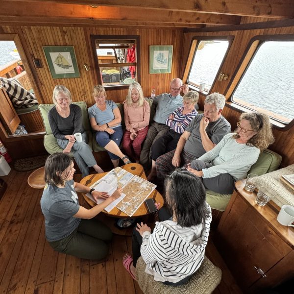 A group of people gathered on a sofa around a chart of Chilean Patagonia