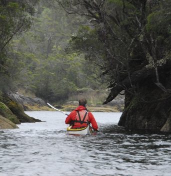 Kayaker paddling through a narrow channel in Chilean Patagonia