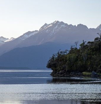 Blue Chilean snowcapped mountains towering over the ocean