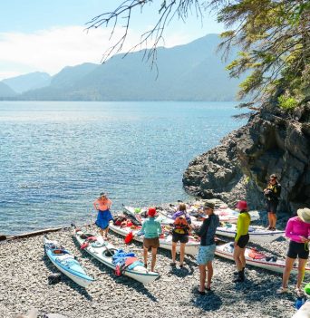 A group of people getting their boats ready for a day of sea kayaking in BC