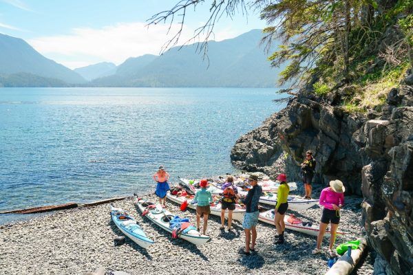 A group of people getting their boats ready for a day of sea kayaking in BC