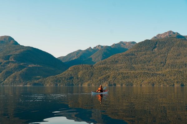 A kayaker paddling through open waters in coastal BC