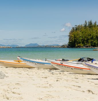 Beached kayaks on a white sand beach