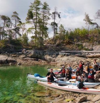 A group of smiling kayakers in British Columbia