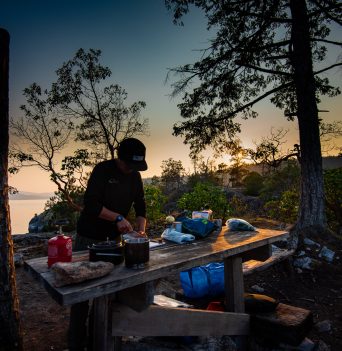 A guide cooking dinner for guests in Desolation Sound