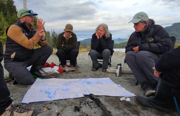 A guide discussing weather and route plans with his guests