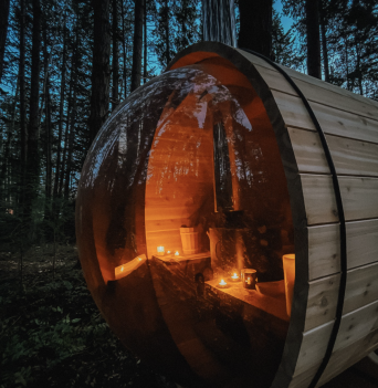 A cedar sauna in the woods at night with candles
